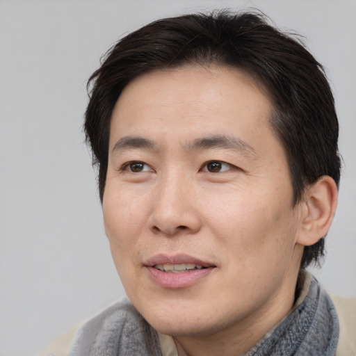 Joyful asian adult male with short  brown hair and brown eyes