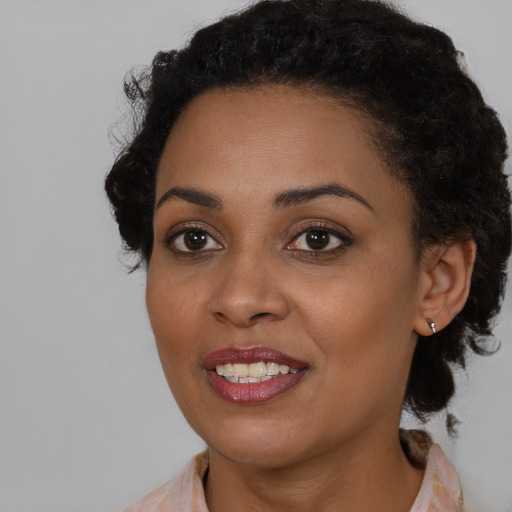Joyful black young-adult female with medium  brown hair and brown eyes