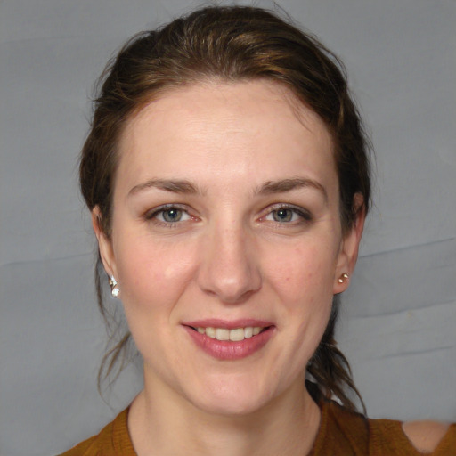 Joyful white young-adult female with medium  brown hair and grey eyes