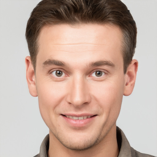 Joyful white young-adult male with short  brown hair and grey eyes