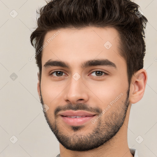 Joyful white young-adult male with short  black hair and brown eyes