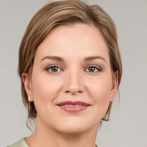 Joyful white young-adult female with medium  brown hair and grey eyes