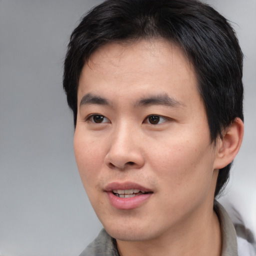 Joyful asian young-adult male with medium  black hair and brown eyes