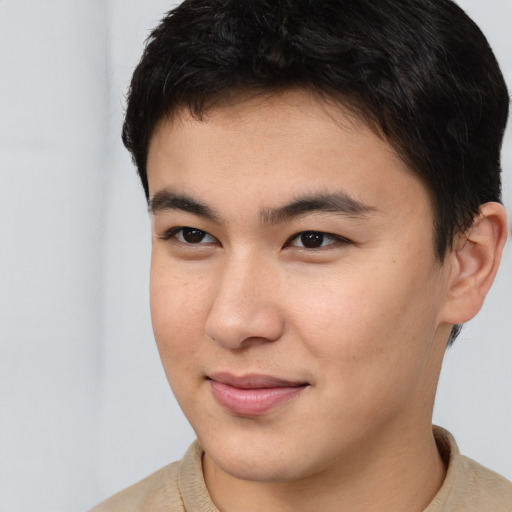 Joyful asian young-adult male with short  brown hair and brown eyes