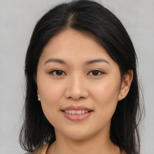 Joyful asian young-adult female with long  brown hair and brown eyes
