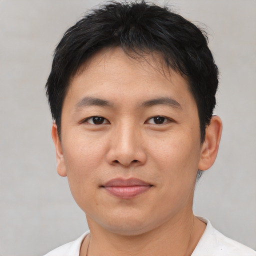 Joyful asian young-adult male with short  black hair and brown eyes
