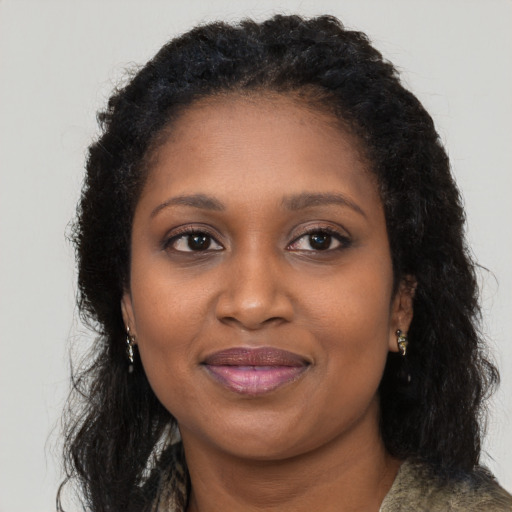 Joyful black young-adult female with long  brown hair and brown eyes