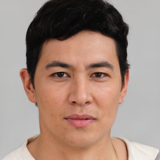 Joyful asian young-adult male with short  brown hair and brown eyes