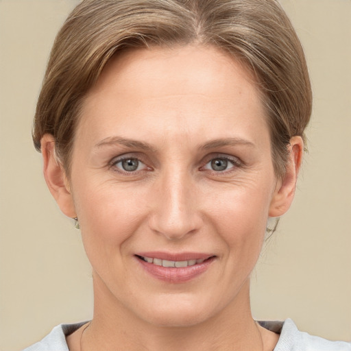 Joyful white adult female with medium  brown hair and grey eyes