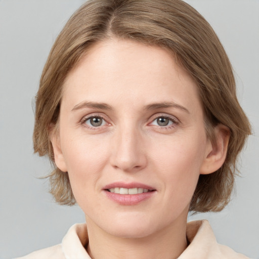 Joyful white young-adult female with medium  brown hair and grey eyes