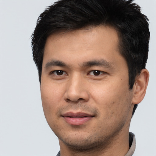 Joyful asian young-adult male with short  brown hair and brown eyes
