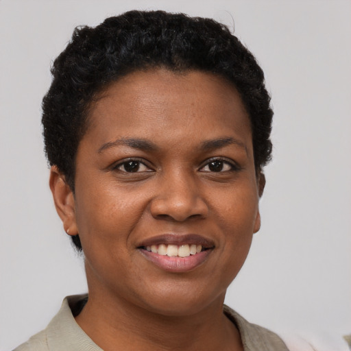 Joyful black young-adult female with short  black hair and brown eyes