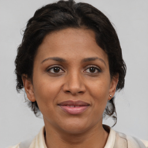 Joyful latino adult female with medium  brown hair and brown eyes