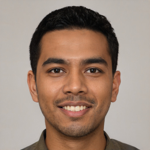 Joyful latino young-adult male with short  black hair and brown eyes