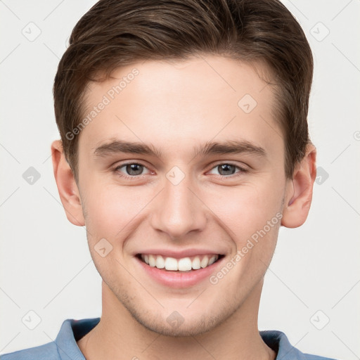 Joyful white young-adult male with short  brown hair and grey eyes