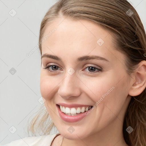 Joyful white young-adult female with long  brown hair and blue eyes