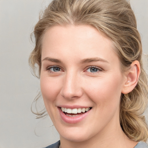 Joyful white young-adult female with medium  brown hair and blue eyes