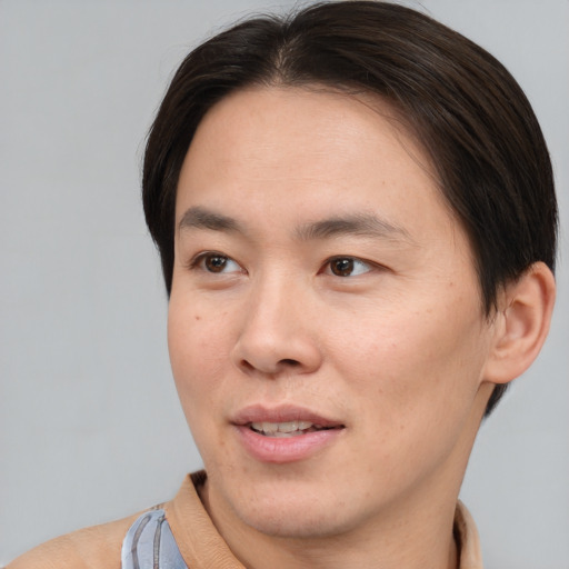 Joyful asian young-adult male with short  brown hair and brown eyes