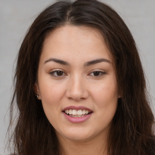 Joyful white young-adult female with long  brown hair and brown eyes