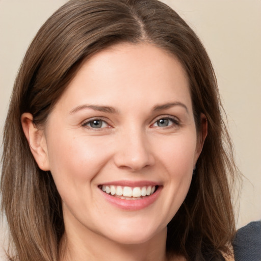 Joyful white young-adult female with long  brown hair and grey eyes