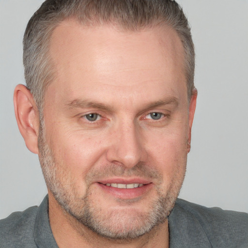 Joyful white adult male with short  brown hair and grey eyes