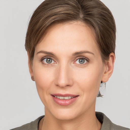 Joyful white young-adult female with short  brown hair and grey eyes