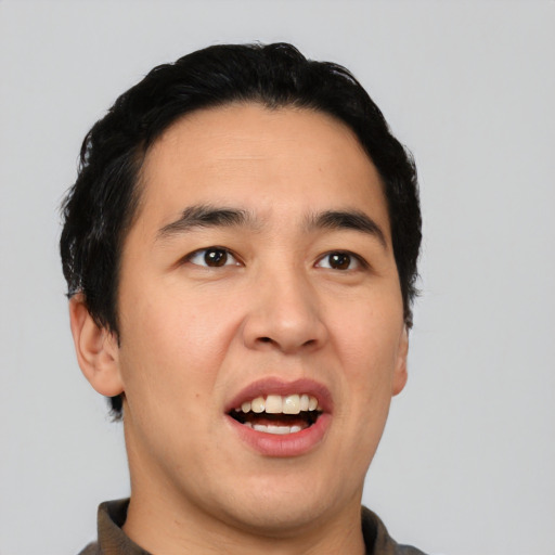 Joyful asian young-adult male with short  black hair and brown eyes