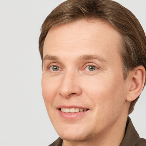 Joyful white adult male with short  brown hair and grey eyes