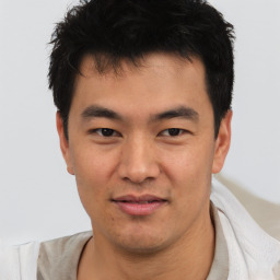 Joyful asian young-adult male with short  black hair and brown eyes