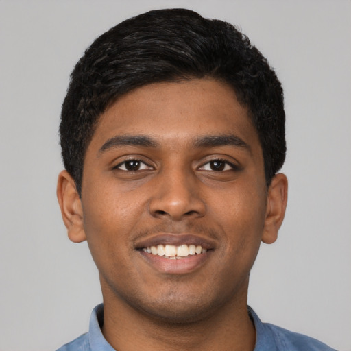 Joyful black young-adult male with short  brown hair and brown eyes