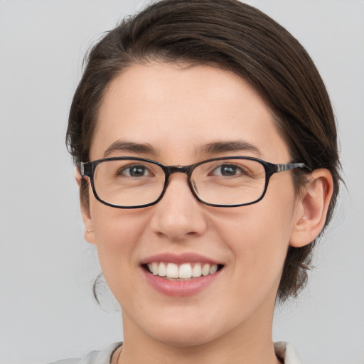 Joyful white young-adult female with medium  brown hair and green eyes