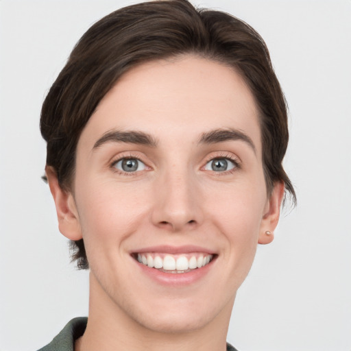 Joyful white young-adult female with short  brown hair and grey eyes