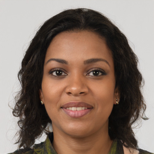 Joyful black young-adult female with long  brown hair and brown eyes