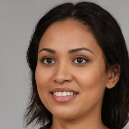 Joyful latino young-adult female with long  brown hair and brown eyes