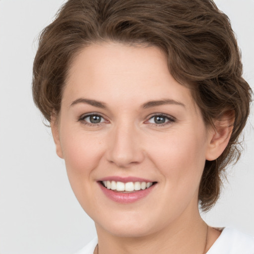 Joyful white young-adult female with medium  brown hair and green eyes