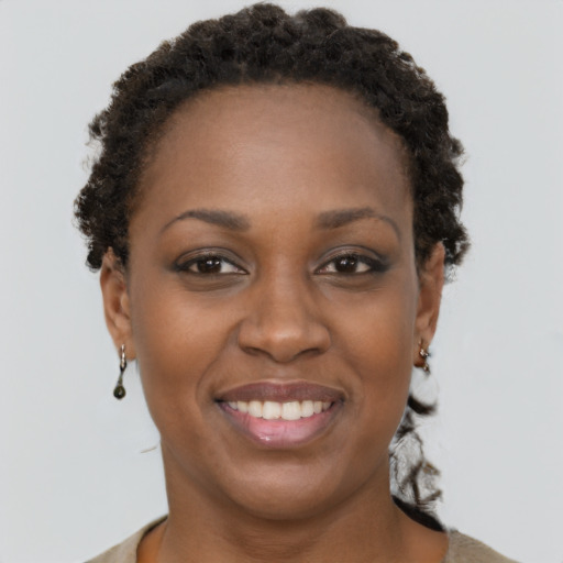 Joyful black adult female with short  brown hair and brown eyes