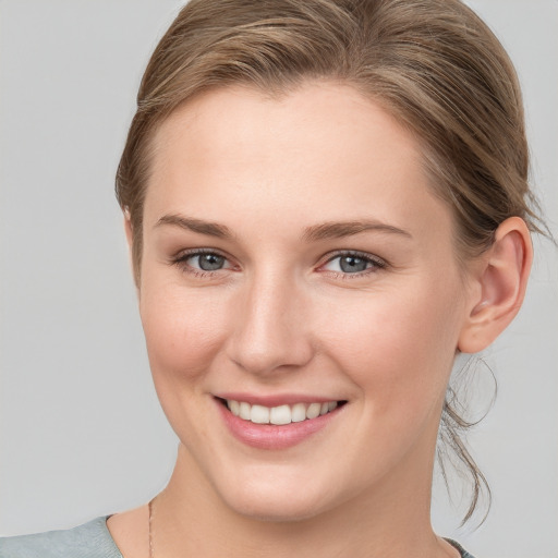 Joyful white young-adult female with medium  brown hair and blue eyes