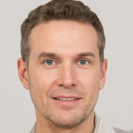 Joyful white adult male with short  brown hair and grey eyes