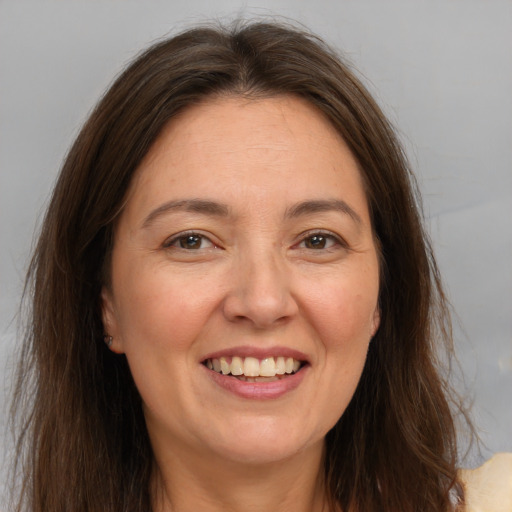 Joyful white adult female with long  brown hair and brown eyes