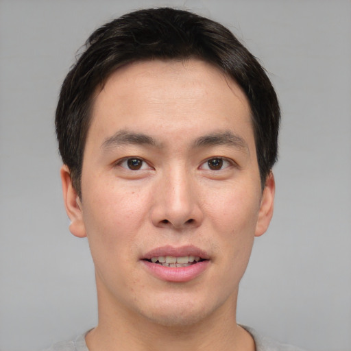 Joyful asian young-adult male with short  brown hair and brown eyes