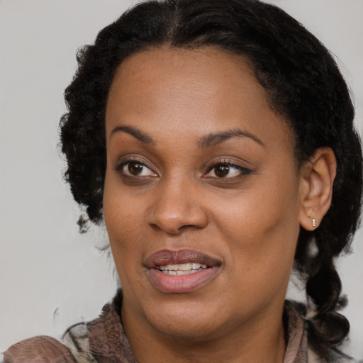 Joyful black young-adult female with long  brown hair and brown eyes