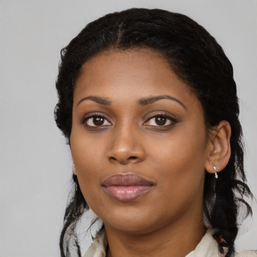 Joyful black young-adult female with long  black hair and brown eyes