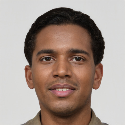 Joyful black young-adult male with short  black hair and brown eyes