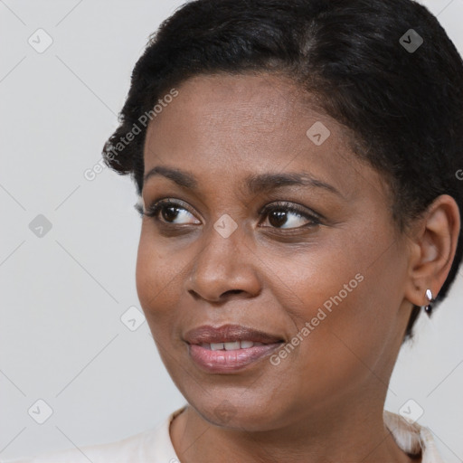 Joyful black young-adult female with short  brown hair and brown eyes