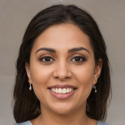 Joyful latino young-adult female with medium  brown hair and brown eyes