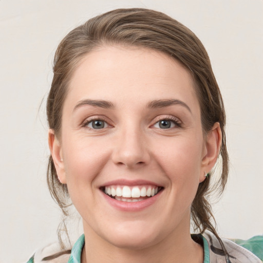 Joyful white young-adult female with medium  brown hair and green eyes