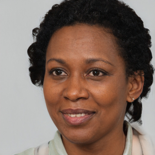 Joyful black adult female with short  black hair and brown eyes