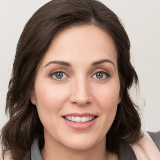 Joyful white young-adult female with medium  brown hair and grey eyes