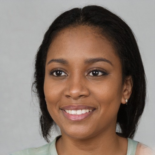 Joyful black young-adult female with medium  black hair and brown eyes