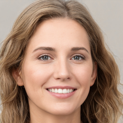 Joyful white young-adult female with long  brown hair and green eyes